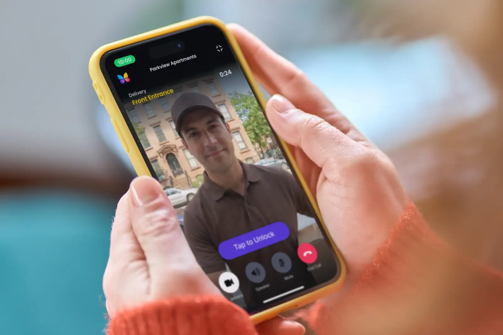 A courier with a parcel calls a resident from a ButterflyMX video intercom and the call shows on the resident’s phone